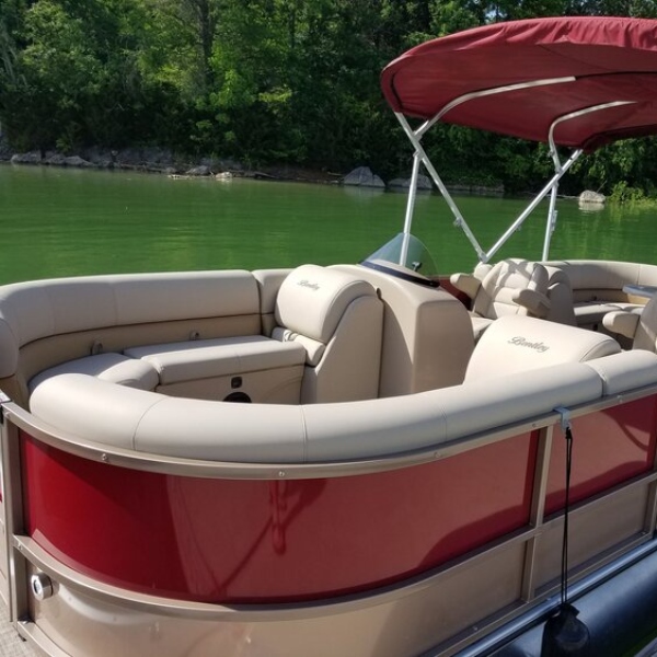 red and beige pontoon boat from lighthouse pointe marina on douglas lake
