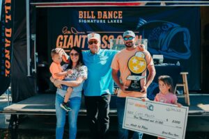 Bill Dance standing with family of Angler who won fishing tournament