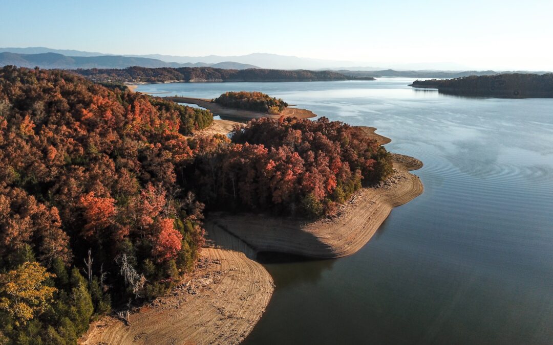 lake with mountains in background and trees in fall season