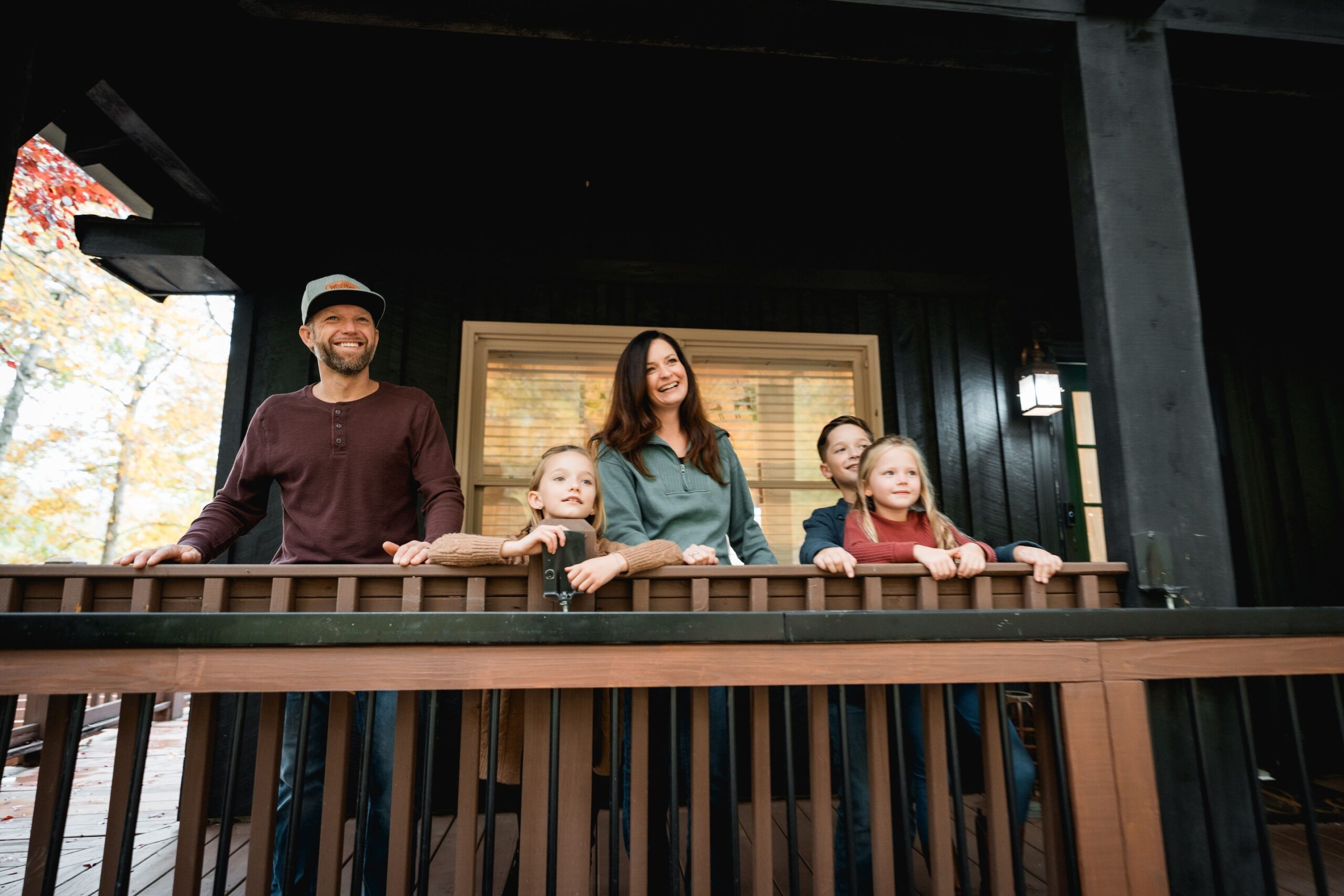 family of 5 standing on the front porch of a mountain cabin in jefferson county tennessee near the great smoky mountains