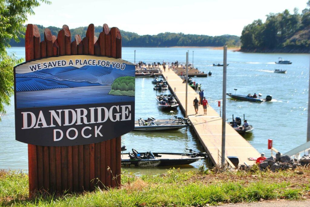 Sign for Dandridge Boat Dock with dock and boats in background
