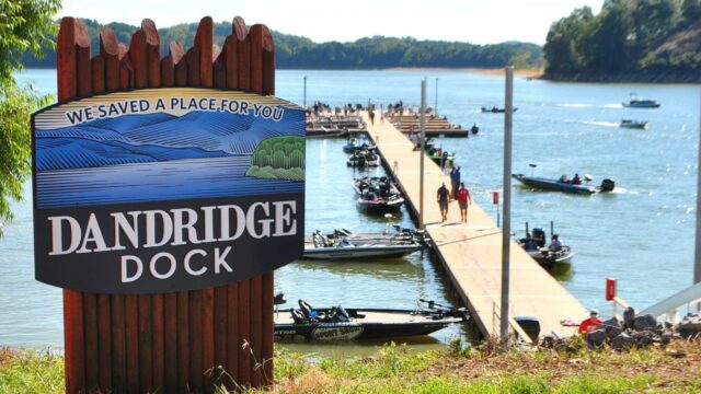 Sign for Dandridge Boat Dock with dock and boats in background