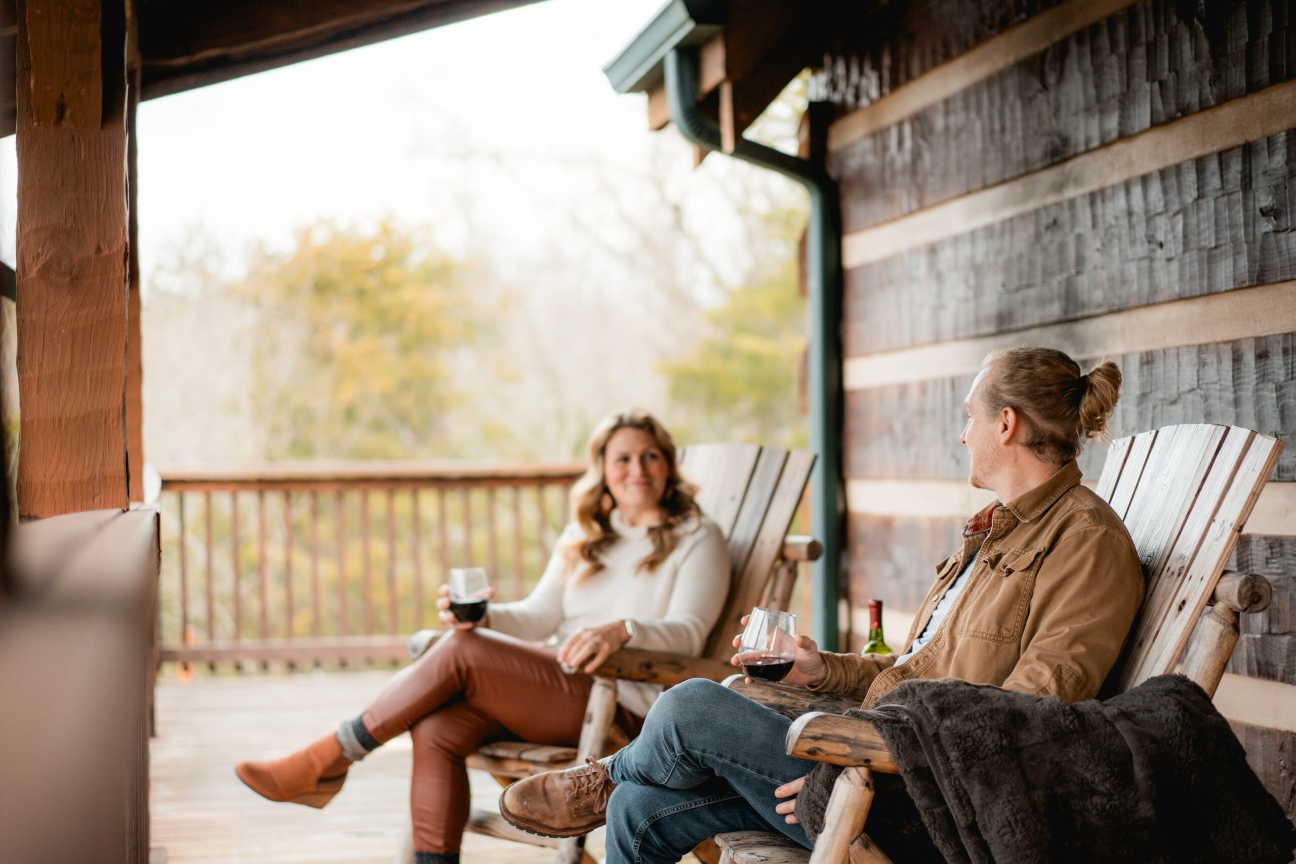 couple sitting on the front porch of a lakeside mountain cabin in jefferson county tennessee