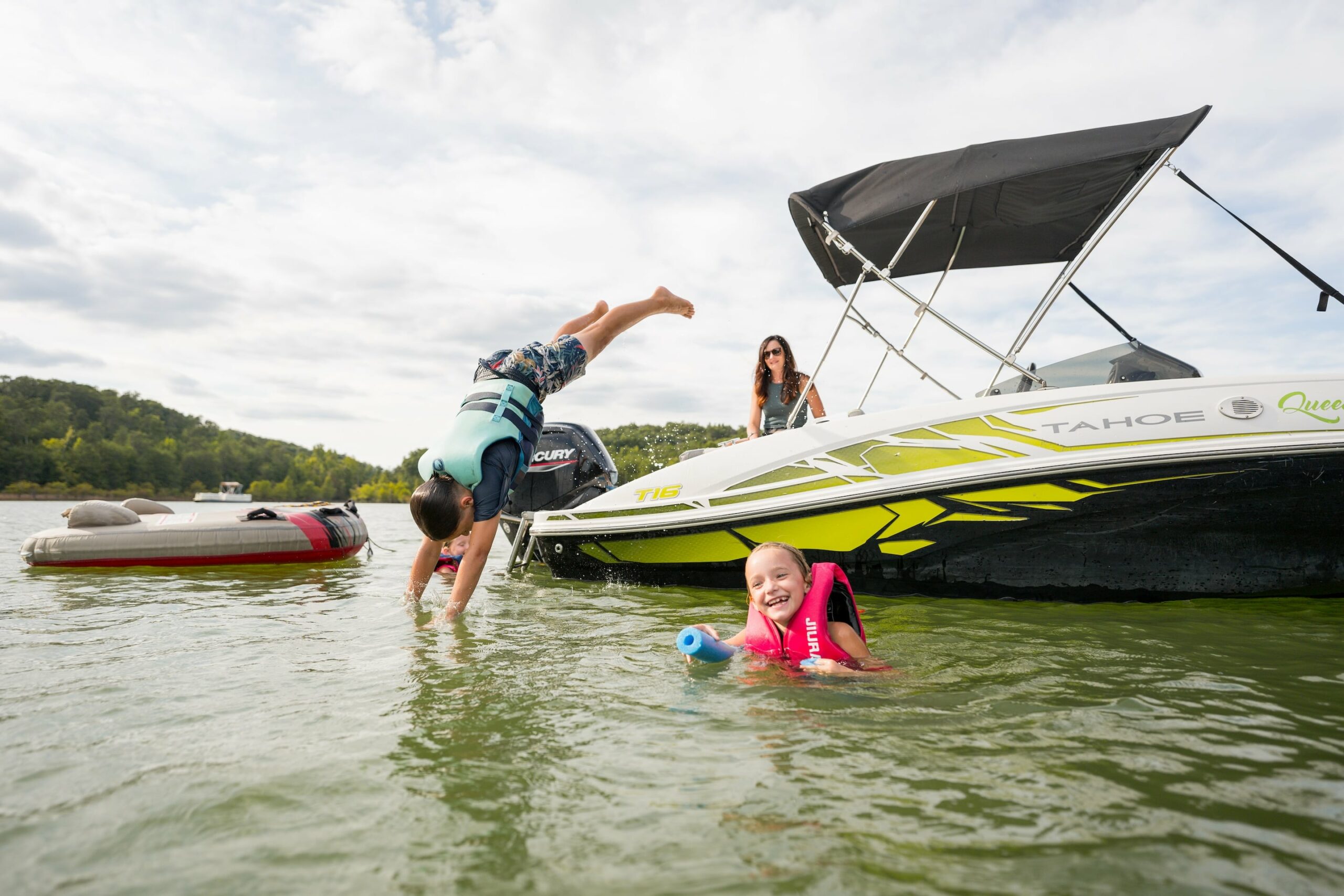 child diving into douglas lake while another child and adult watch, family enjoying a lake day on douglas lake