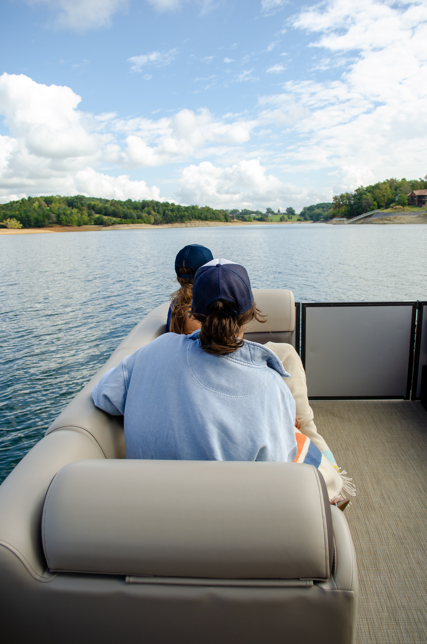 Woman in pontoon boat looking out across the water at fall colors