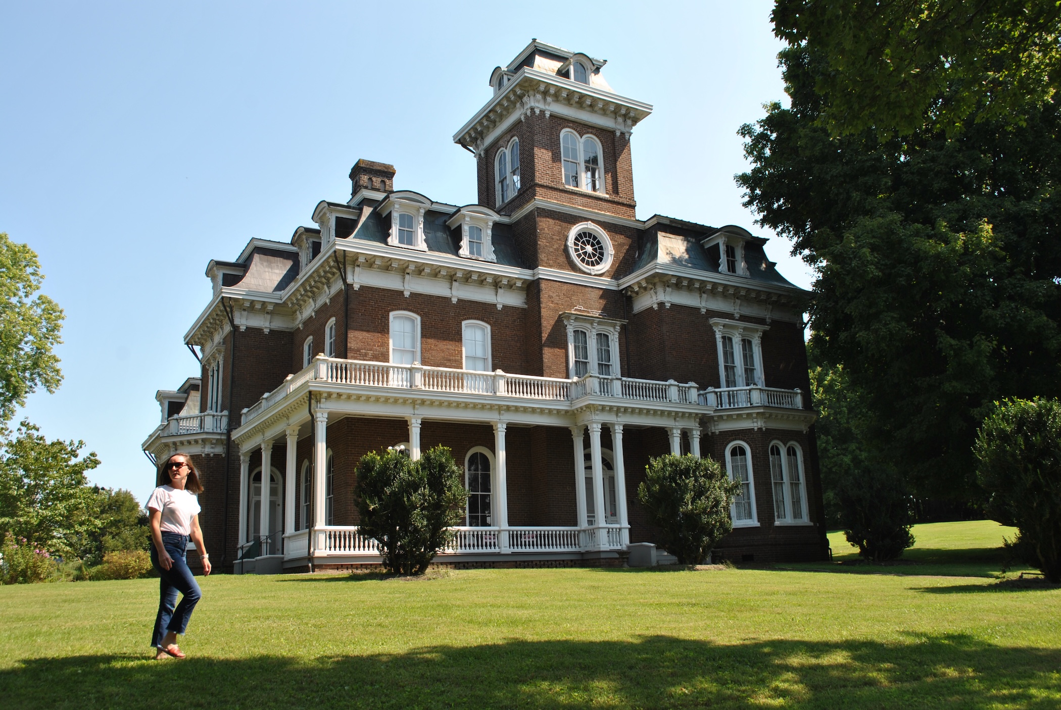 Woman walking outside of Glenmore Mansion, a Victorian Home built in 1868.