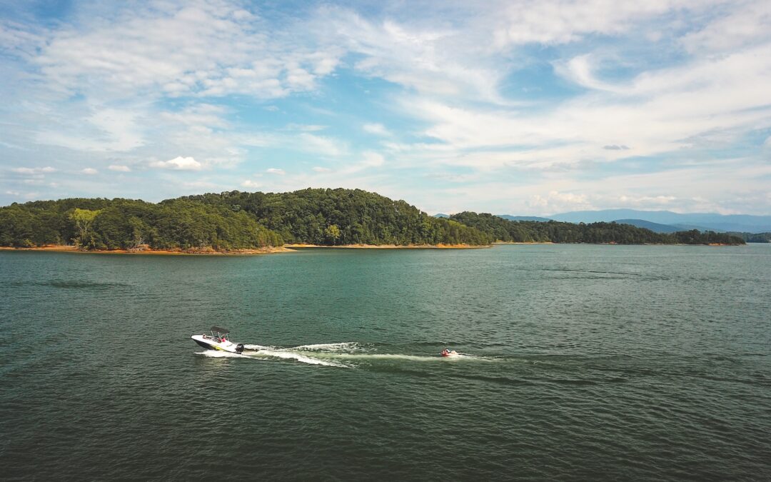 Drone view of boat pulling a tube on Douglas Lake with Smoky Mountains in the background