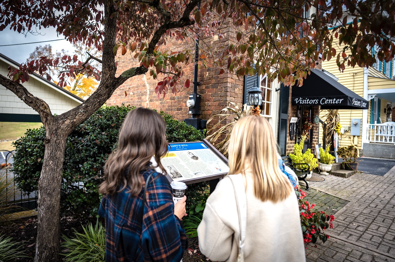 Two women reading a sign in front of the historic vistors center in Dandridge, TN