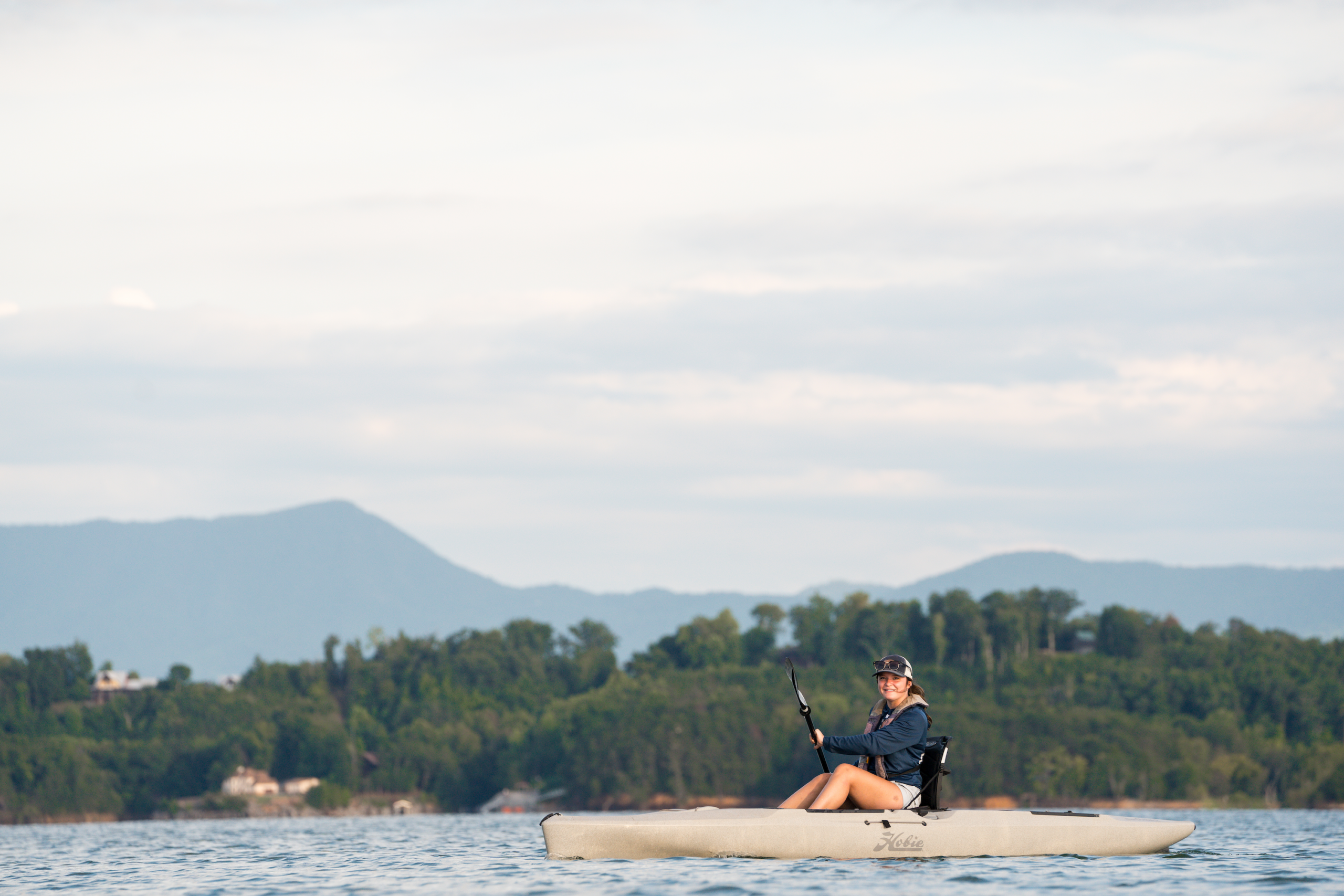 Woman Kayaking on Douglas Lake with Smoky Mountains in the background