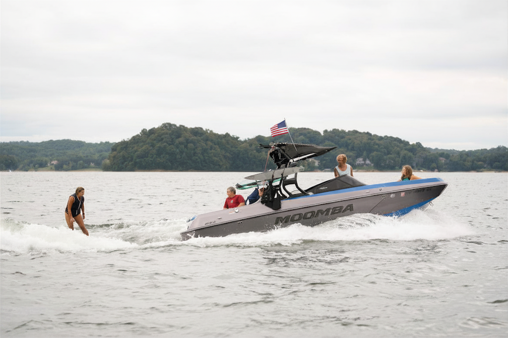 Boat pulling water skier as people cheer her on